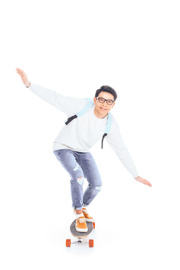 白で隔離のスケート ボードに乗ってのバックパックでアジアの 10 代 - 写真・画像