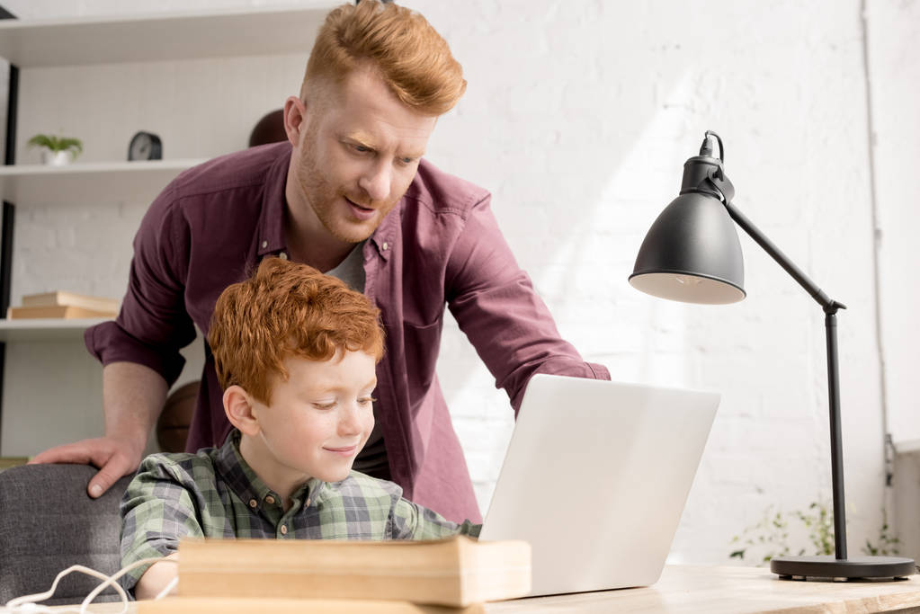 Redhead otec a syn doma společně pomocí přenosného počítače - Fotografie, Obrázek