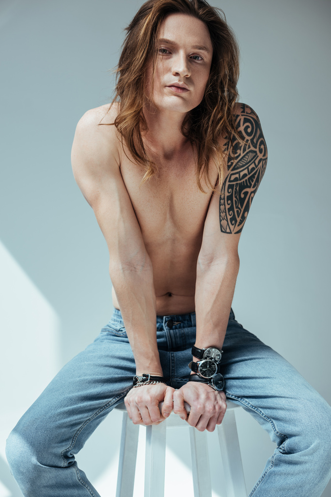 seksikäs paidaton mies pitkät hiukset ja tatuointi käsillä, harmaa
  - Valokuva, kuva