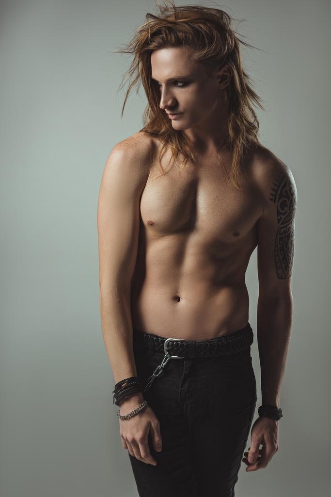 sexy hemdloses männliches Model posiert in schwarzen Jeans, isoliert auf grau - Foto, Bild