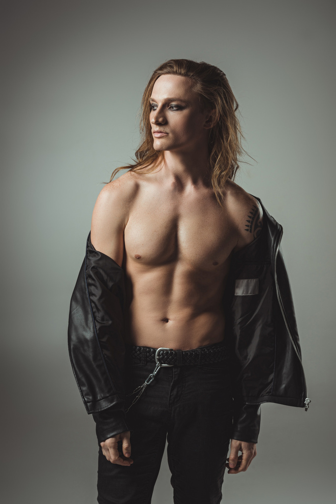 shirtless rocker with tattoo posing in black leather jacket, isolated on grey - Photo, Image