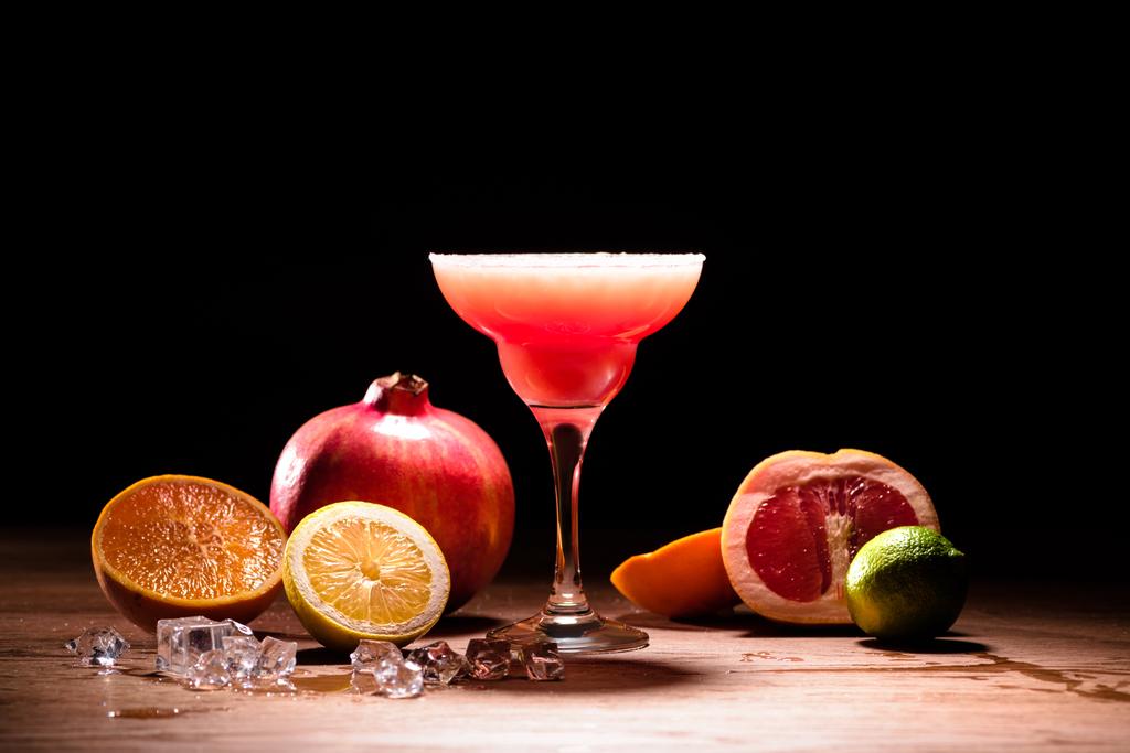 bebida alcoólica vermelha com frutas e cubos de gelo na mesa de madeira
 - Foto, Imagem