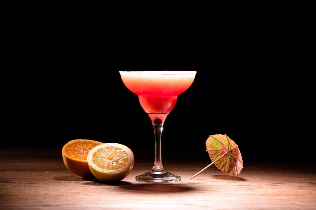 red alcohol cocktail with orange and lemon on wooden table - Photo, Image