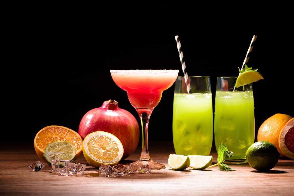 bebidas alcoólicas com limão, romã e cubos de gelo na mesa
 - Foto, Imagem