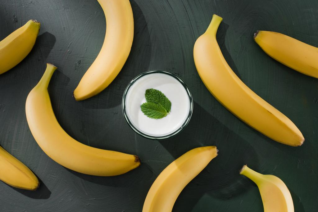 вид зверху на банани і молочний коктейль з м'ятою на столі
 - Фото, зображення