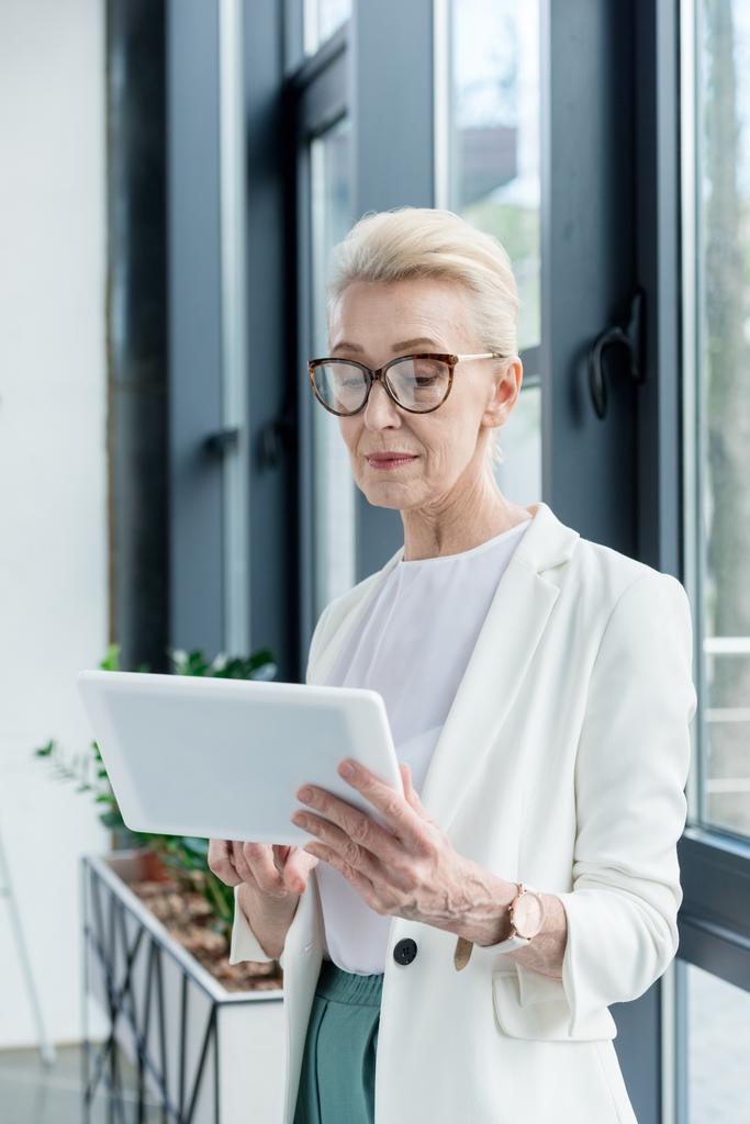 attractive senior businesswoman in eyeglasses using digital tablet - Photo, Image