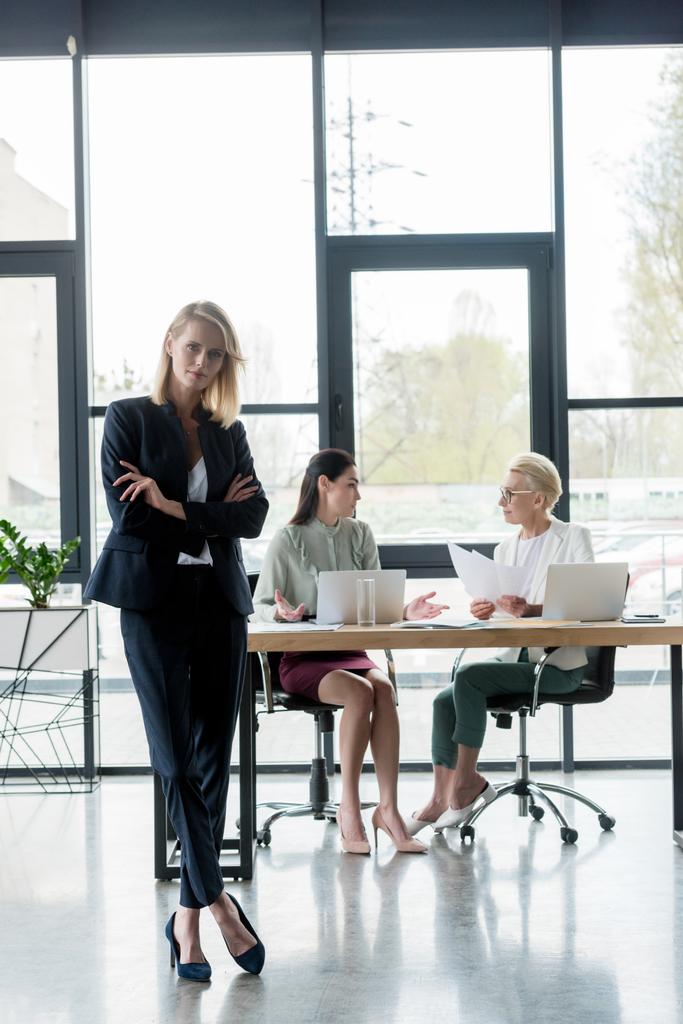 beautiful businesswoman standing with crossed arms at meeting in office - Photo, Image