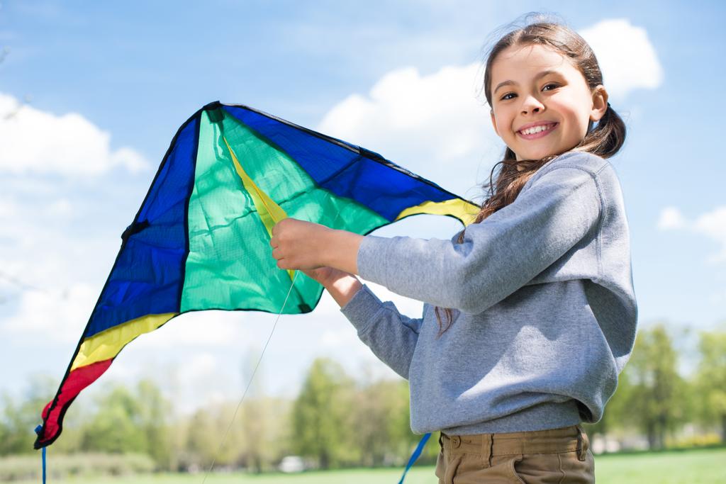 uśmiechający się małe dziecko trzymając latawca w parku - Zdjęcie, obraz