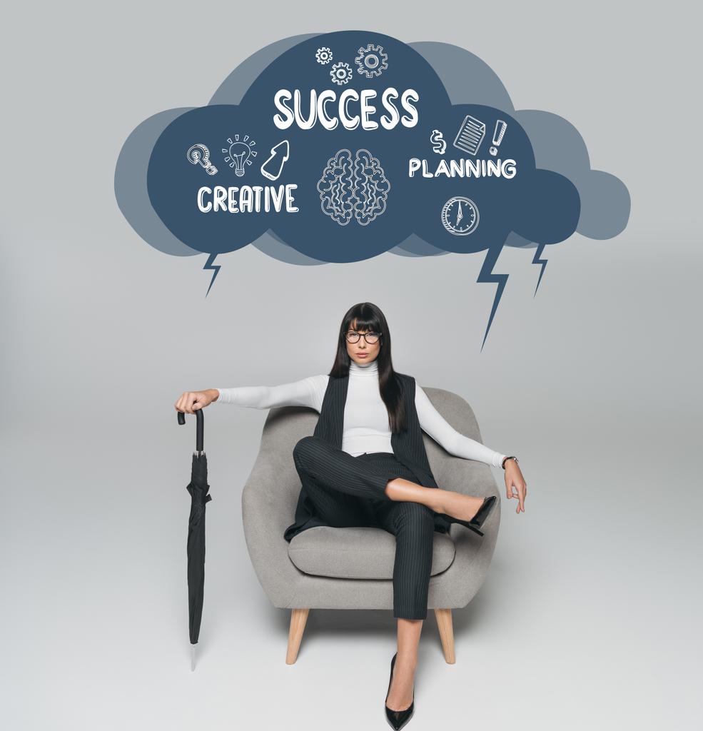 красивая брюнетка деловая женщина сидит на кресле с зонтиком на сером, облако с творческим, успеха и планирования надпись выше
 - Фото, изображение
