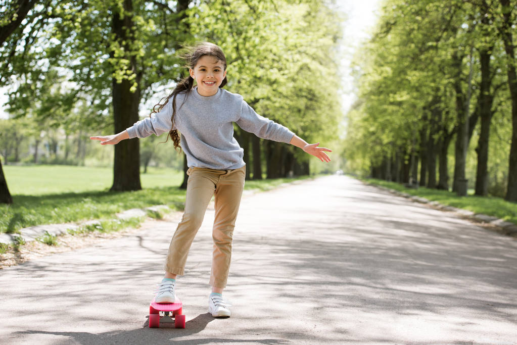 маленький ребенок со скейтбордом на дорожке в парке
 - Фото, изображение