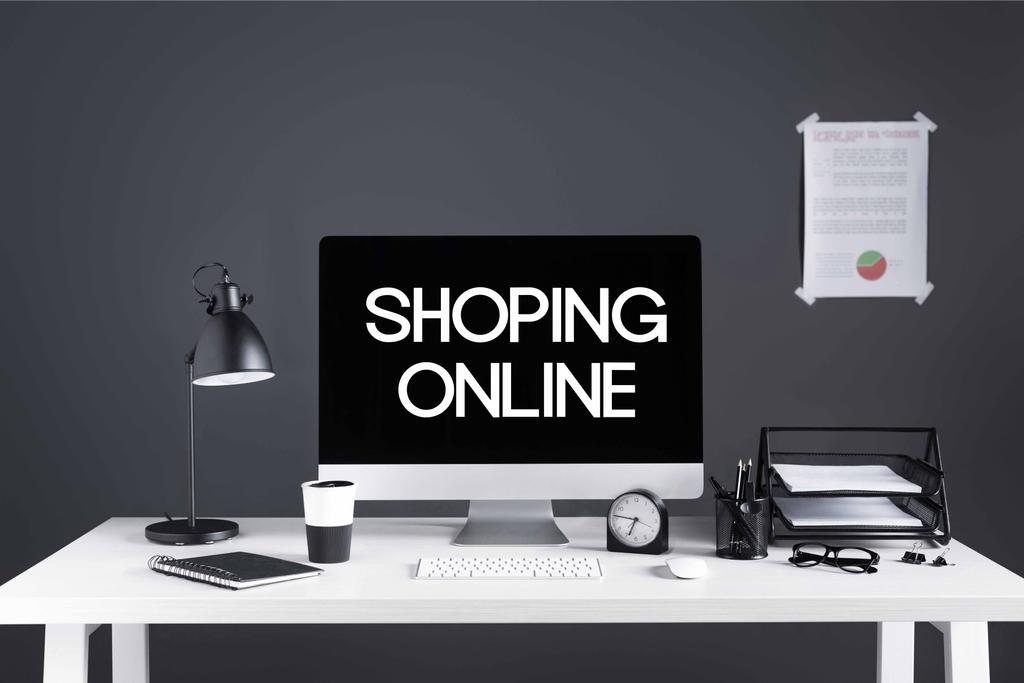 настільний комп'ютер з покупками онлайн-напис на екрані, бізнес-графіку, годинник і канцелярське приладдя на робочому місці
  - Фото, зображення
