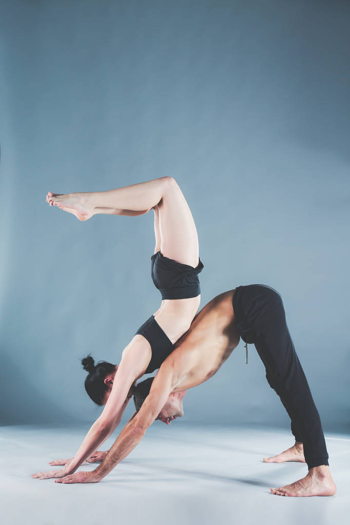 Genç çift Acro yoga mat Studio birlikte uygulamak. Acroyoga. Çift yoga. Ortak yoga. - Fotoğraf, Görsel