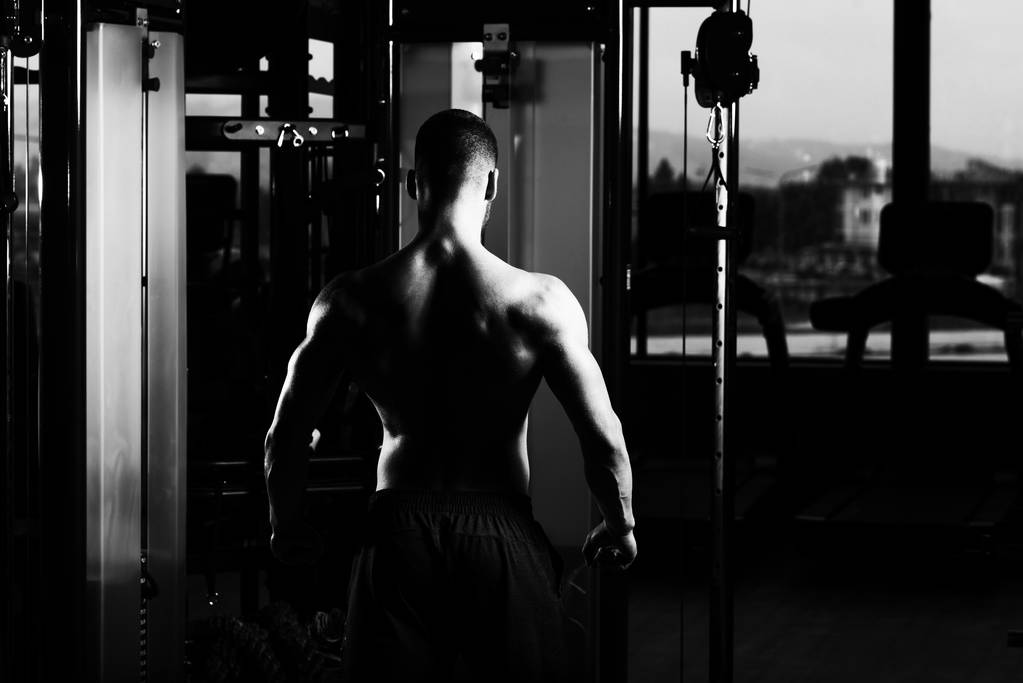 muskularny mężczyzna wyginanie mięśni w siłowni - Zdjęcie, obraz