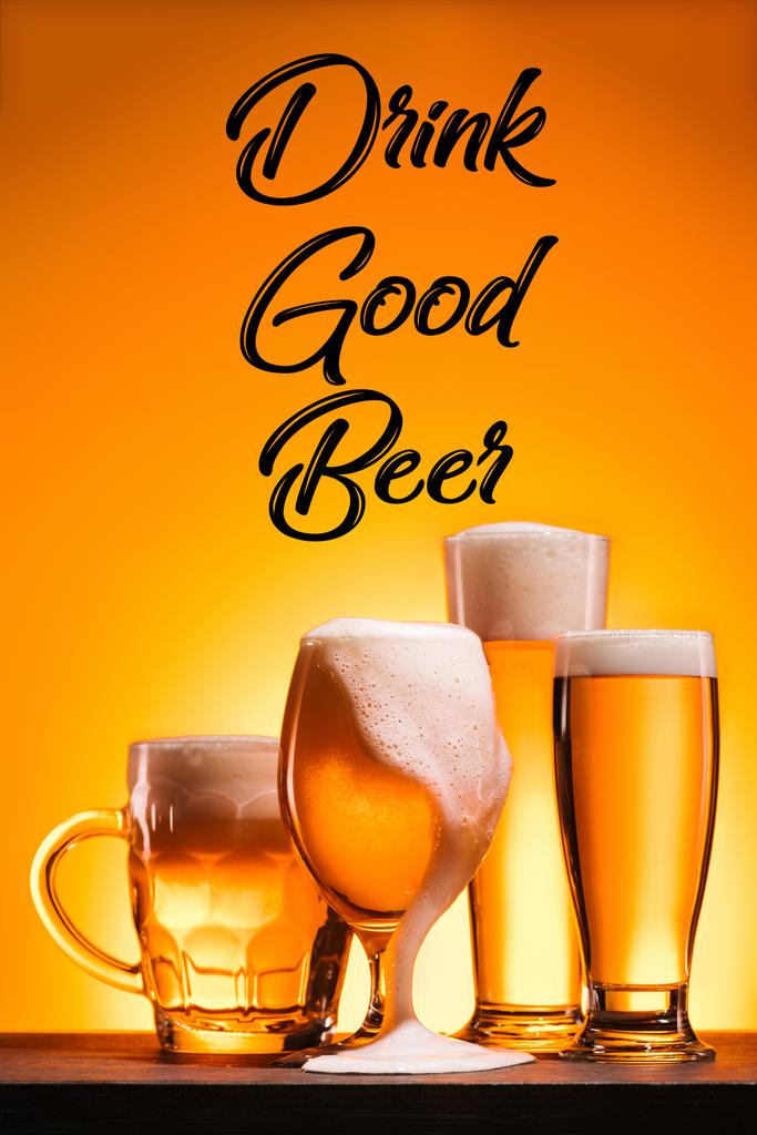 lähikuva järjestetty mukeja kylmää olutta vaahto ja juoda hyvää olutta merkintä oranssi tausta
 - Valokuva, kuva
