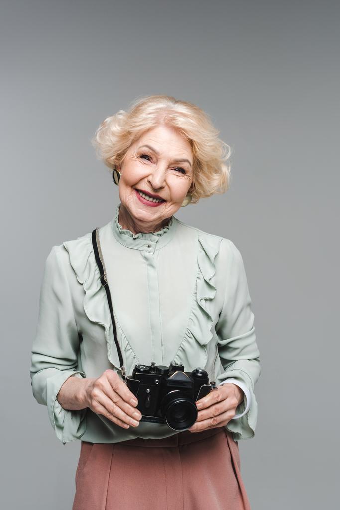 szczęśliwy senior kobiety z rocznika film kamery na szarym tle - Zdjęcie, obraz