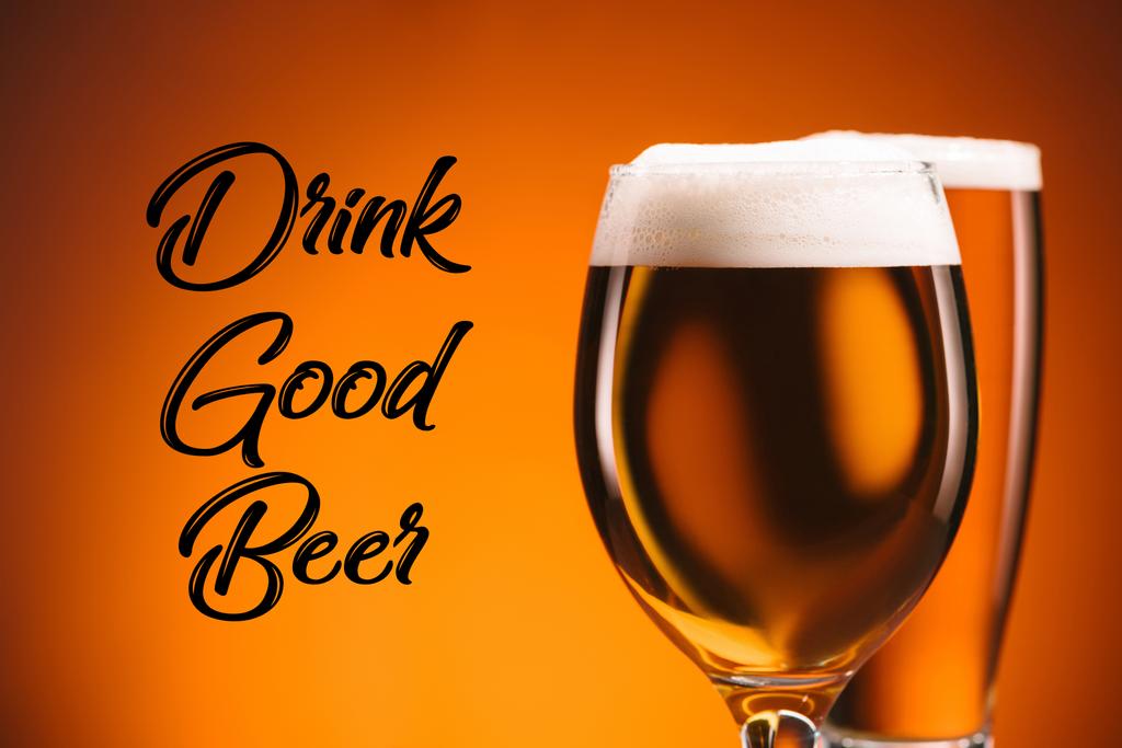 primer plano vista de disposición de vasos de cerveza y beber buena inscripción de cerveza sobre fondo naranja
 - Foto, Imagen