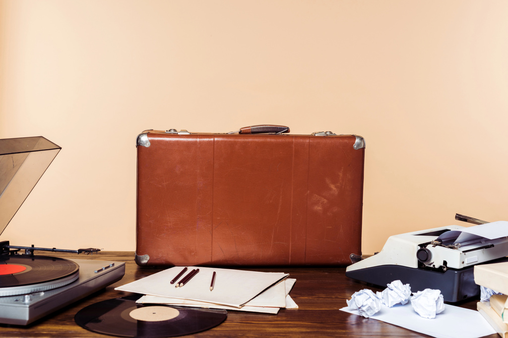 вінтажна валіза, вініловий диск, програвач і друкарська машинка на столі
  - Фото, зображення