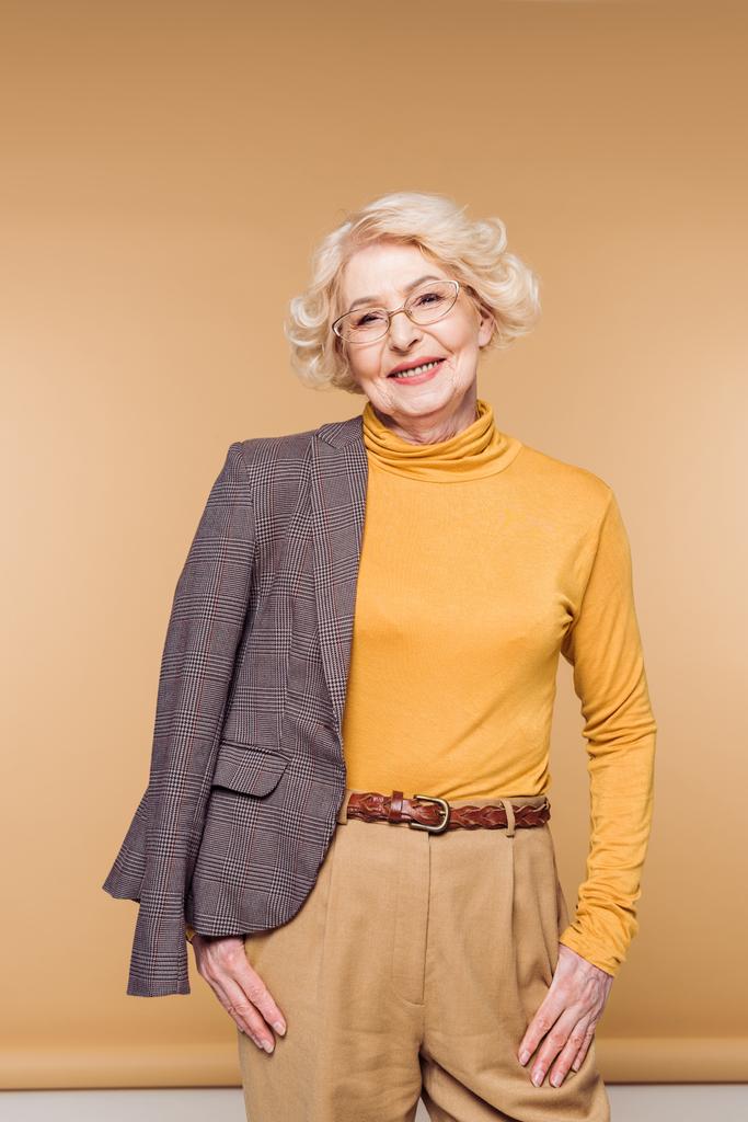 ジャケットの肩の上に保持している眼鏡で幸せのファッショナブルな年配の女性 - 写真・画像