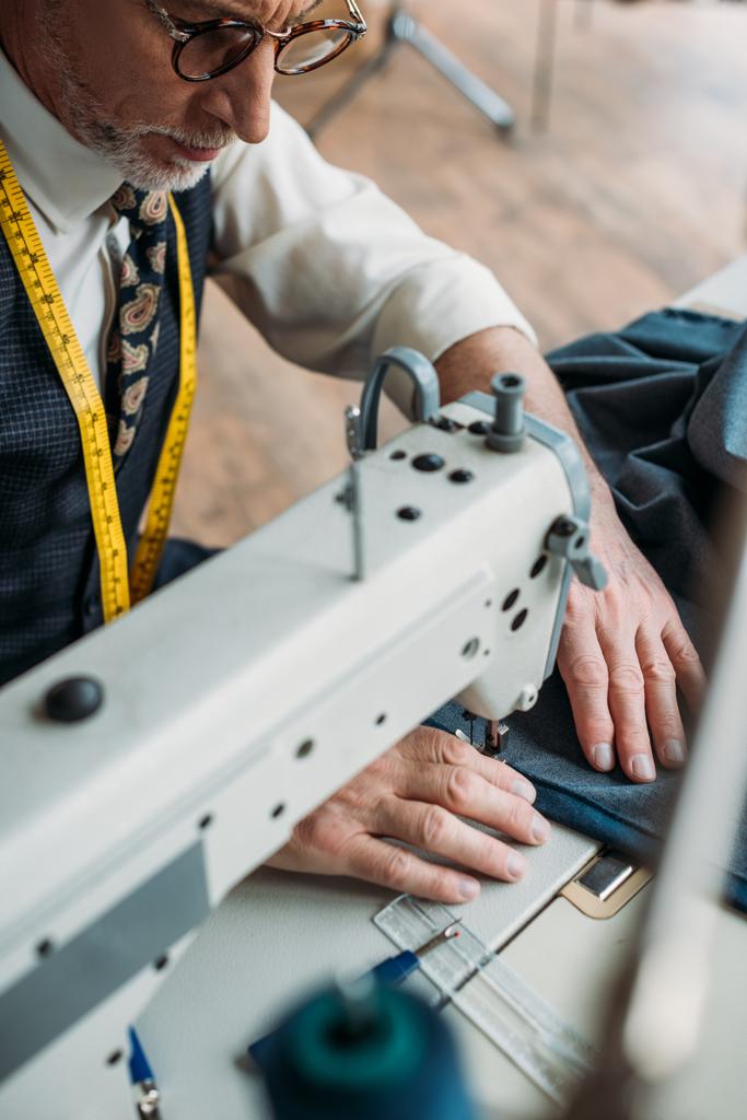 гарний професійний кравець швейної тканини з швейною машиною в швейній майстерні
 - Фото, зображення