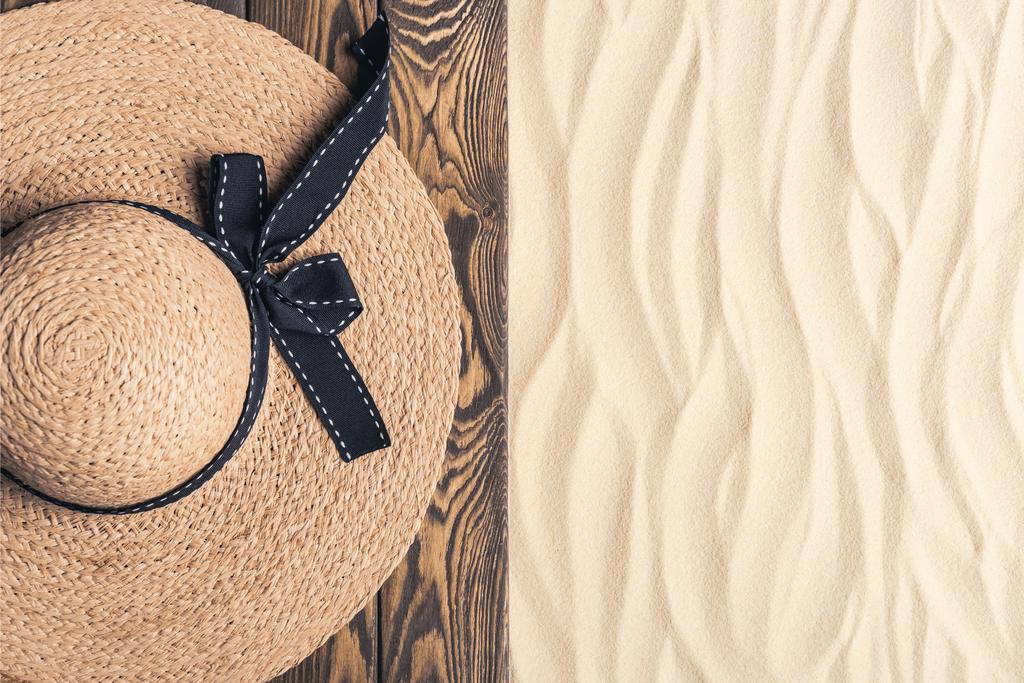 Sombrero de paja en muelle de madera en la playa de arena
 - Foto, imagen