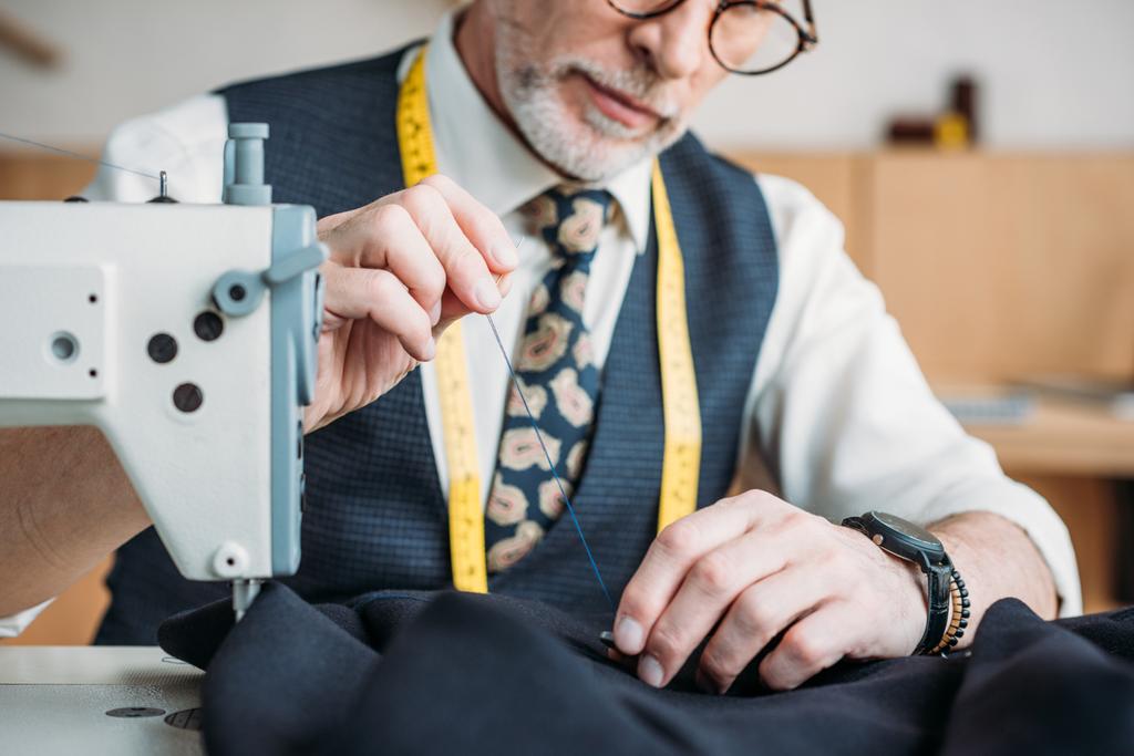 imagen recortada del botón de costura sastre senior a la chaqueta en el taller de costura
 - Foto, imagen