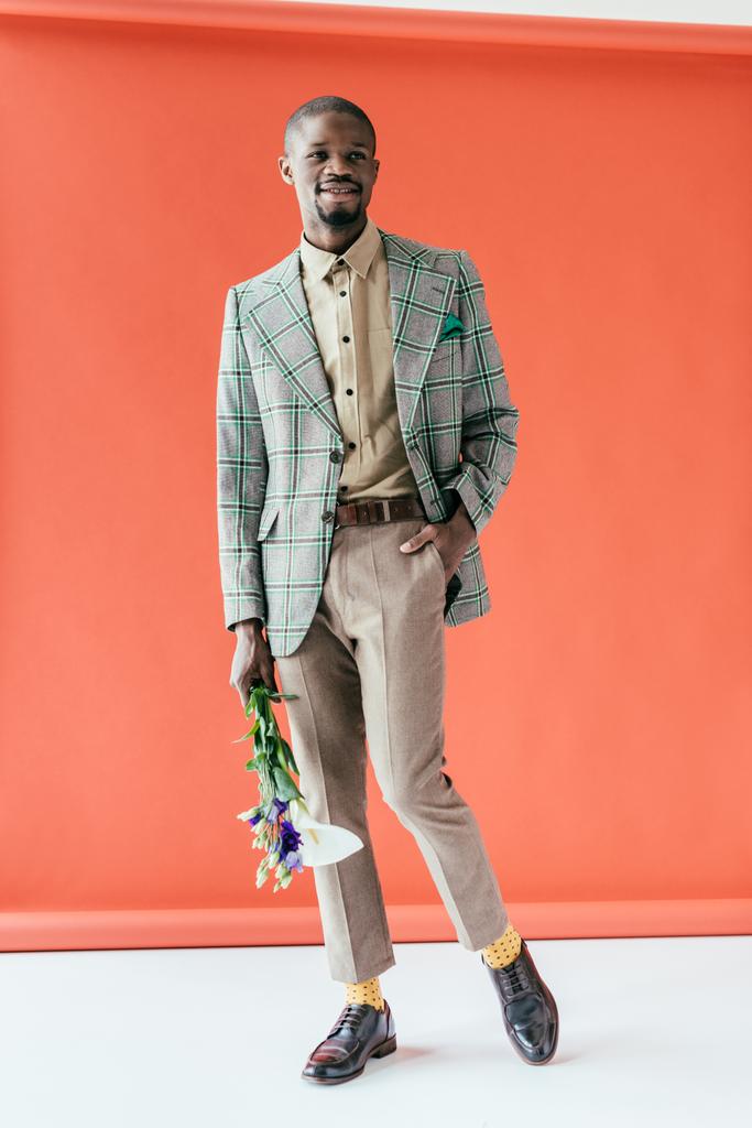 модный африканский американец в ретро куртке с цветами, на красном
 - Фото, изображение