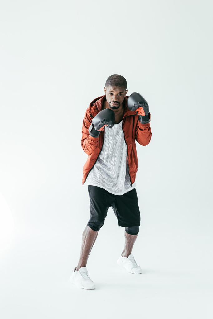 Афроамериканский боксер, тренирующийся в боксёрских перчатках, изолированный по белому
 - Фото, изображение