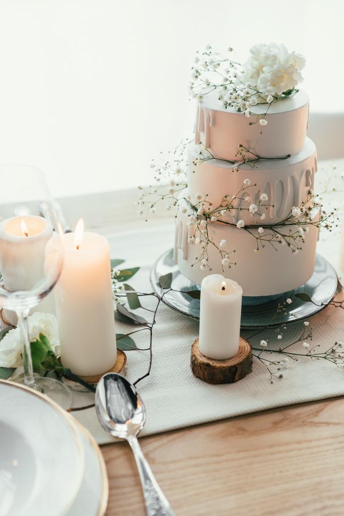 vue rapprochée du décor élégant de la table avec des bougies et gâteau de mariage pour mariage rustique
 - Photo, image