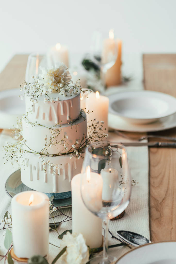 キャンドルと素朴な結婚式のためのウエディング ケーキとスタイリッシュなテーブル設定のクローズ アップ表示 - 写真・画像