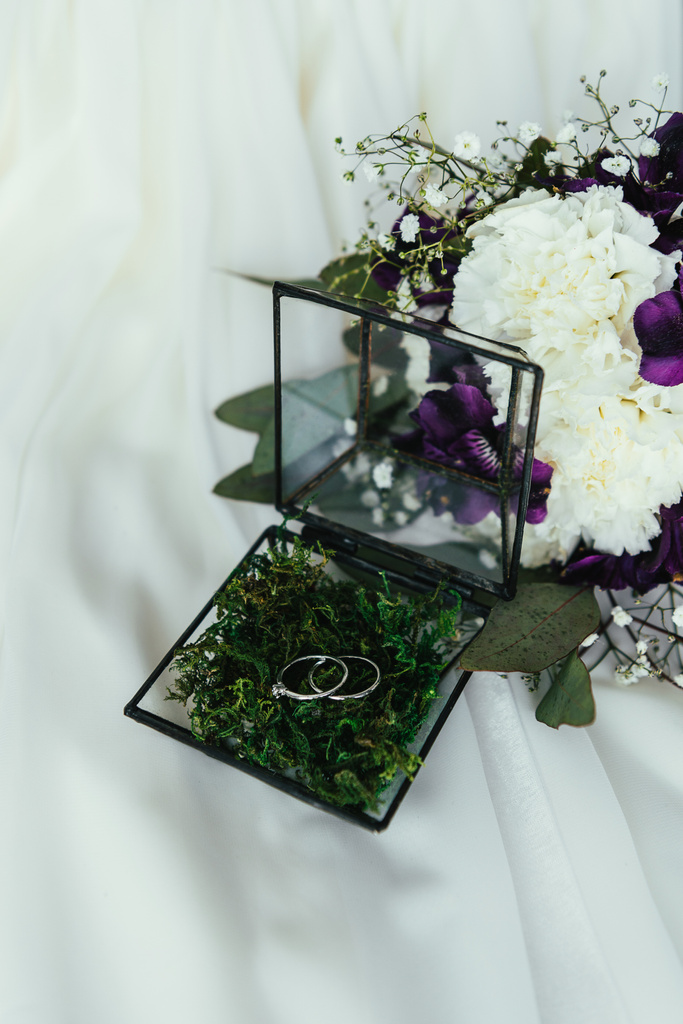 zblízka pohled snubní prsteny v rustikální a krásnou svatební kytici na bílém prádle - Fotografie, Obrázek