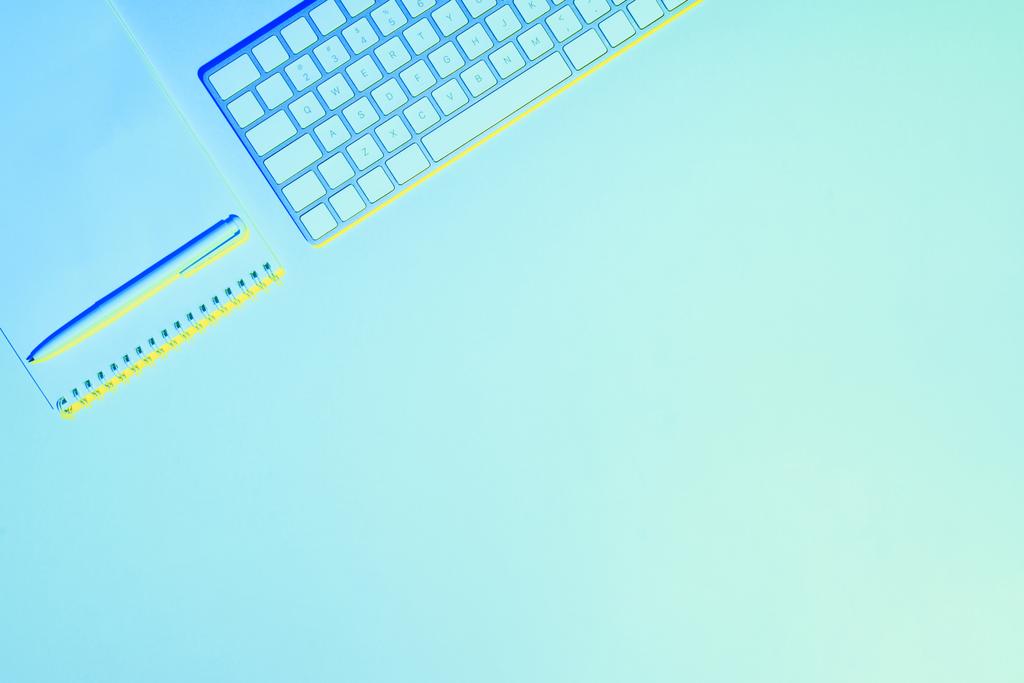 blau getöntes Bild von Computertastatur, leerem Lehrbuch und Stift - Foto, Bild