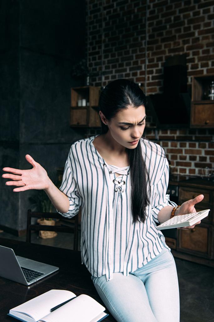 hämmentynyt nuori nainen laskimen laskenta vero kotona ja silppuaminen hartiat
 - Valokuva, kuva