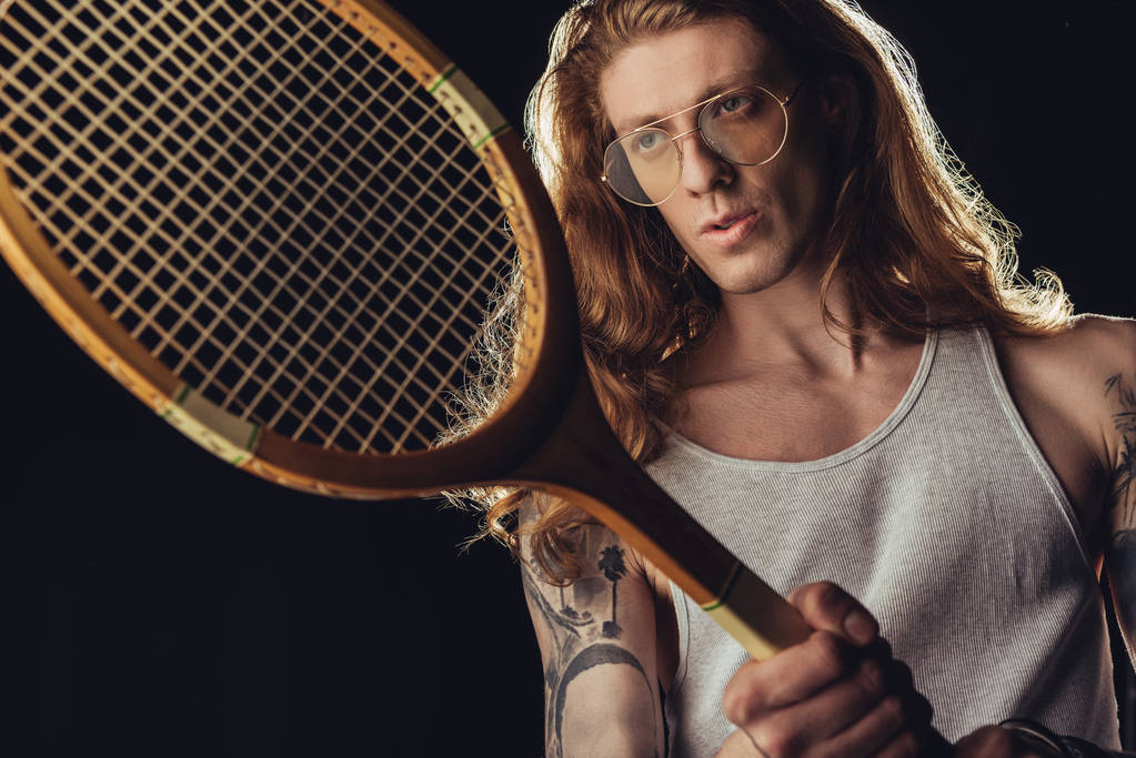 стильный теннисист с винтажной деревянной ракеткой, изолированный на черном
 - Фото, изображение