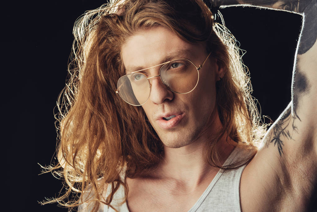 portrait of fashionable man with long hair in stylish glasses, isolated on black - Photo, Image