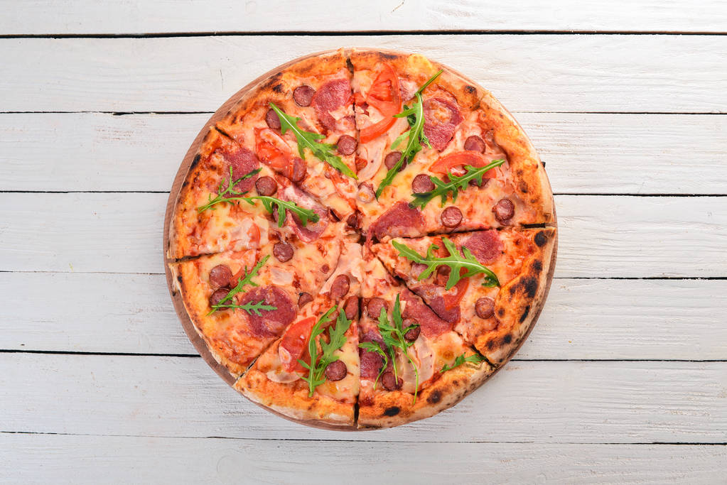 Pizza mit Wurstsalami und Mozzarella. Ansicht von oben. auf einem hölzernen Hintergrund. Kopierraum. - Foto, Bild