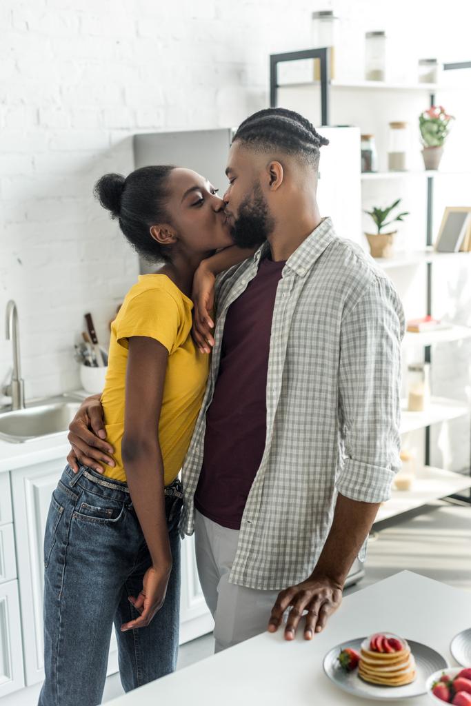 africano americano pareja besos en cocina
 - Foto, imagen