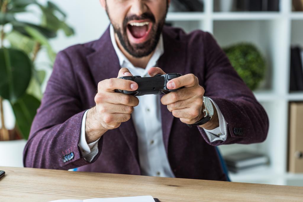 Oříznout záběr křičí mladý podnikatel hraní her s gamepad - Fotografie, Obrázek