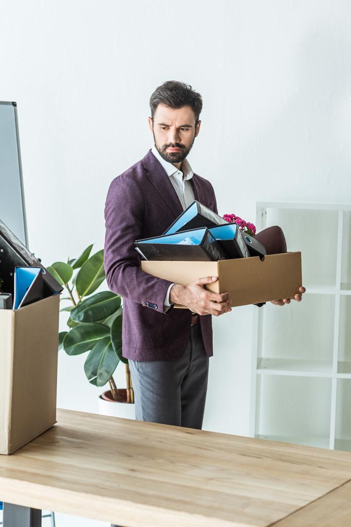 potkut nuori liikemies kuljettaa laatikko henkilökohtaisia tavaroita toimistossa
 - Valokuva, kuva