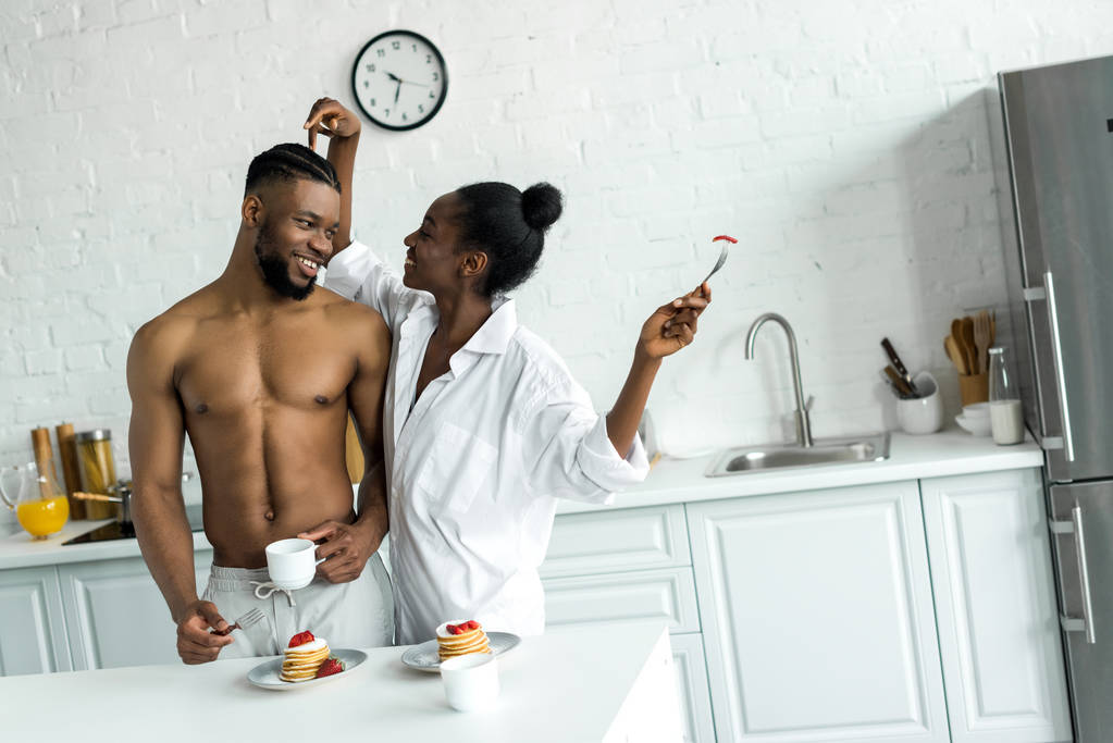 キッチンで彼氏の頭に触れることアフリカ系アメリカ人のガール フレンド - 写真・画像