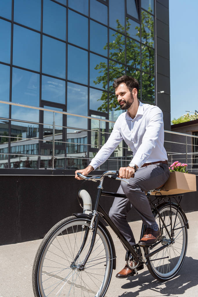 joven gerente feliz montar en bicicleta con caja en el maletero
 - Foto, imagen