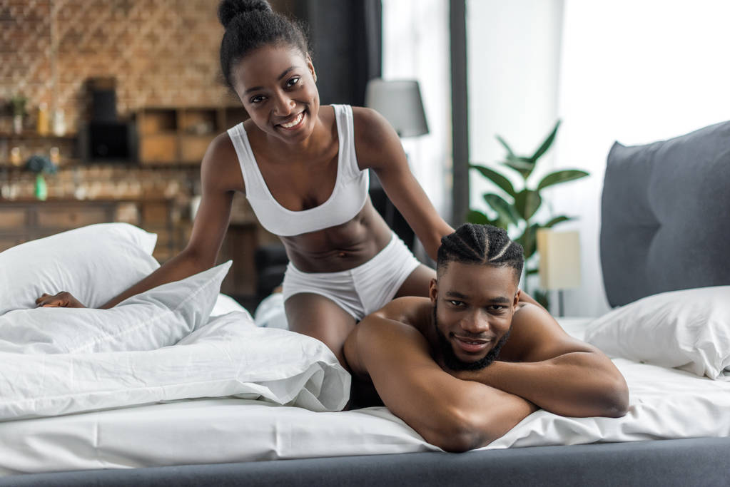 mosolygó afro-amerikai házaspár fehérnemű látszó-on fényképezőgép, a hálószobában - Fotó, kép