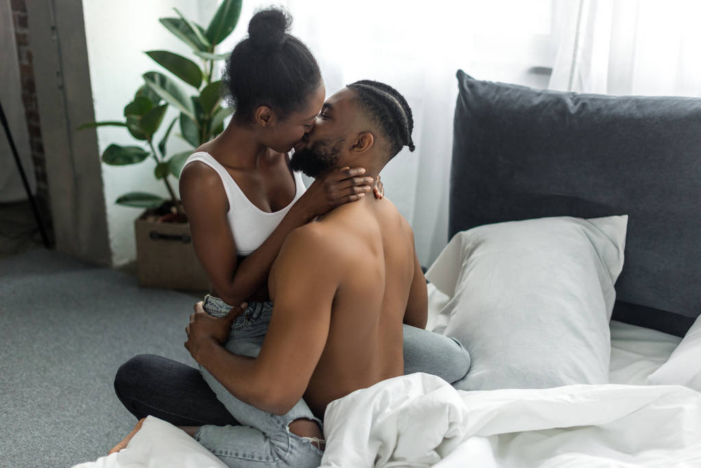 ласковая африканская американская пара целуется в спальне
 - Фото, изображение