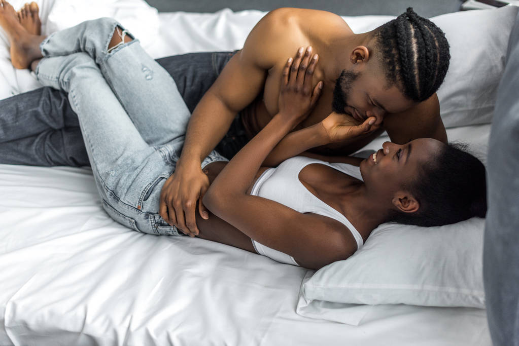 Afrikanisch-amerikanisches Paar liegt auf Bett im Schlafzimmer - Foto, Bild
