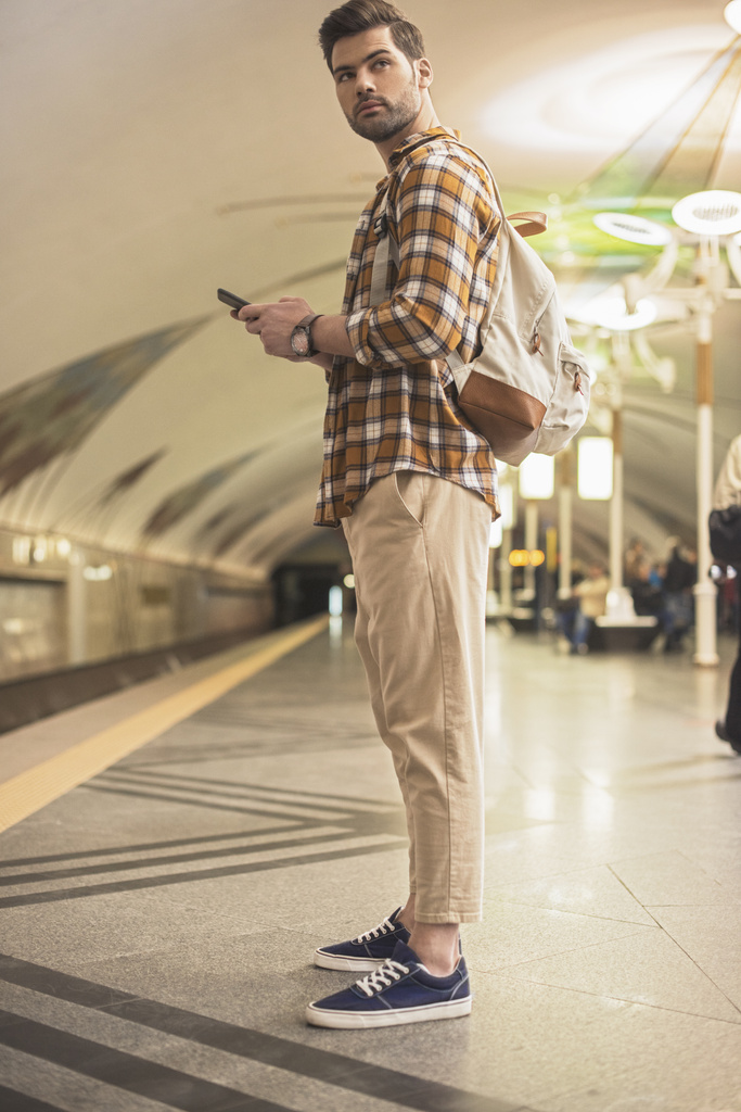 homme élégant avec sac à dos et smartphone à la station de métro
  - Photo, image