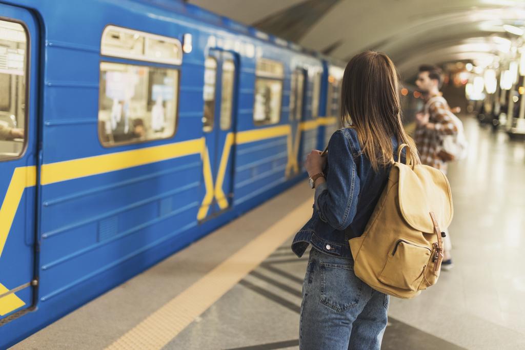 vista posteriore di elegante turista donna con zaino in piedi alla stazione della metropolitana
  - Foto, immagini