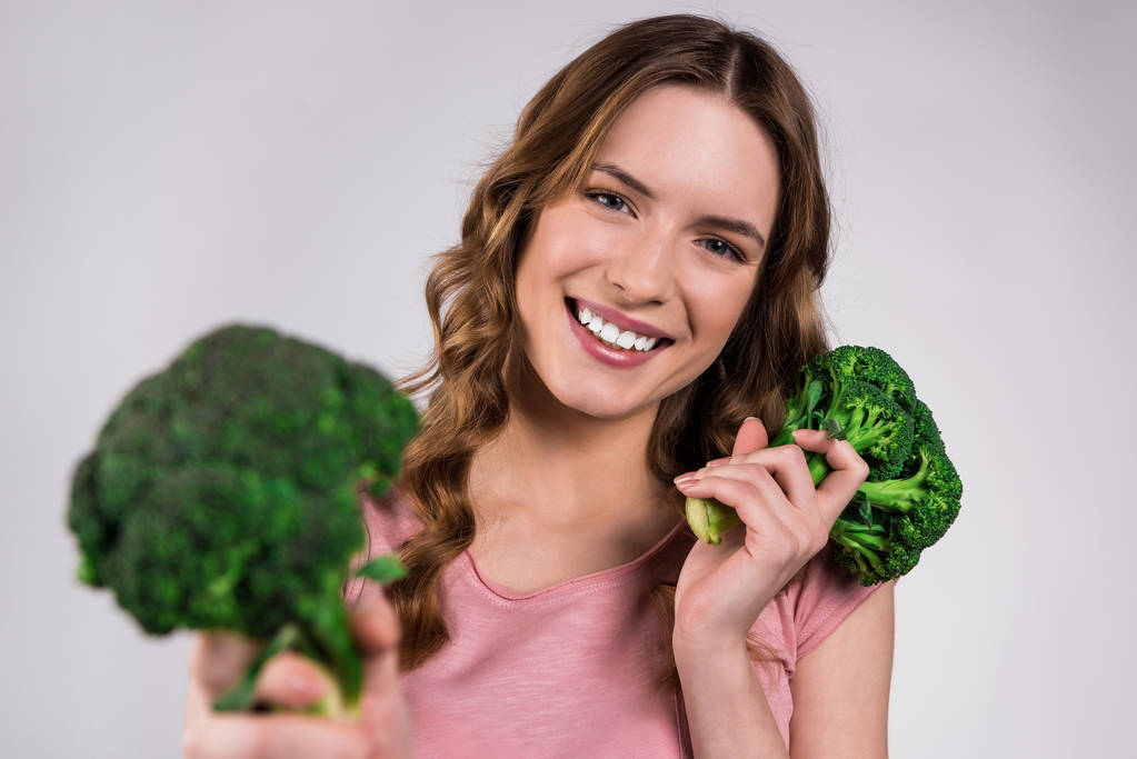 Gülümseyen kız izole brokoli ile poz. - Fotoğraf, Görsel