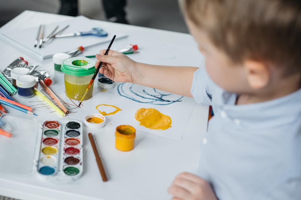 Selektywny fokus mały chłopiec z pędzlem i malarstwo rysunek obraz sam w domu - Zdjęcie, obraz