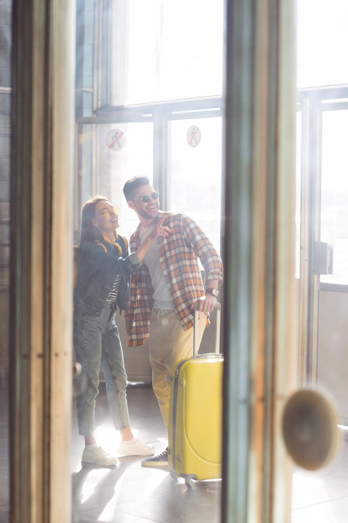 жіночий мандрівник вказує пальцем на хлопця з колісною сумкою в метро
  - Фото, зображення