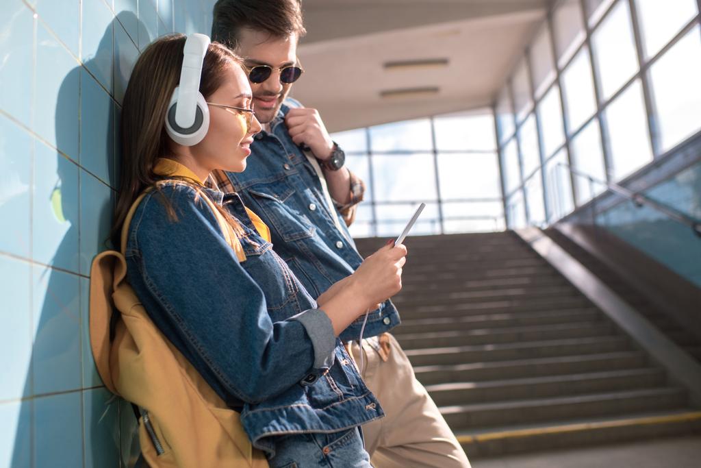 pareja elegante de turistas mirando la pantalla del teléfono inteligente en el metro
  - Foto, Imagen