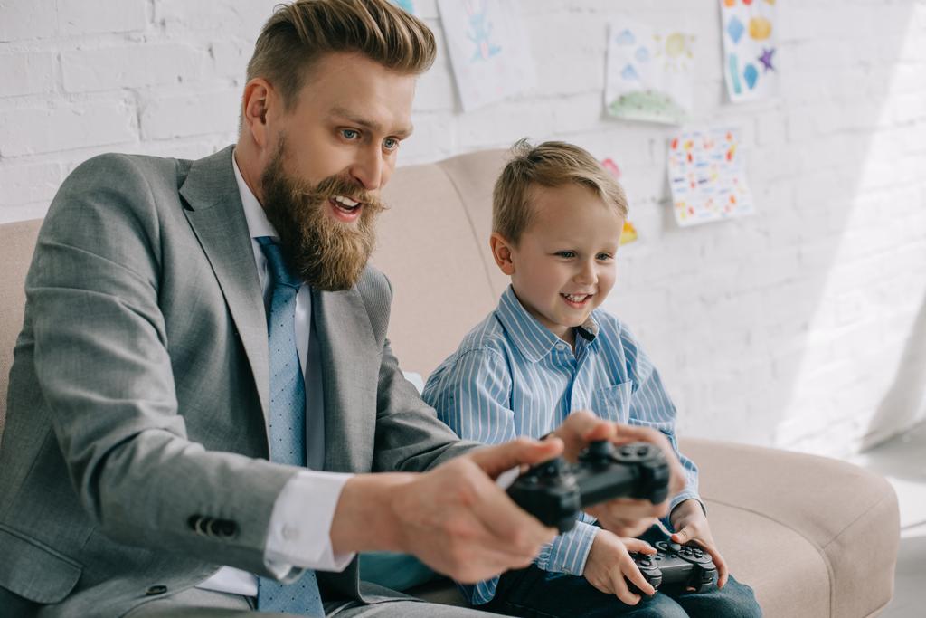 実業家と幼い息子の家で一緒にビデオゲームを遊んで、仕事と生活のバランス概念 - 写真・画像